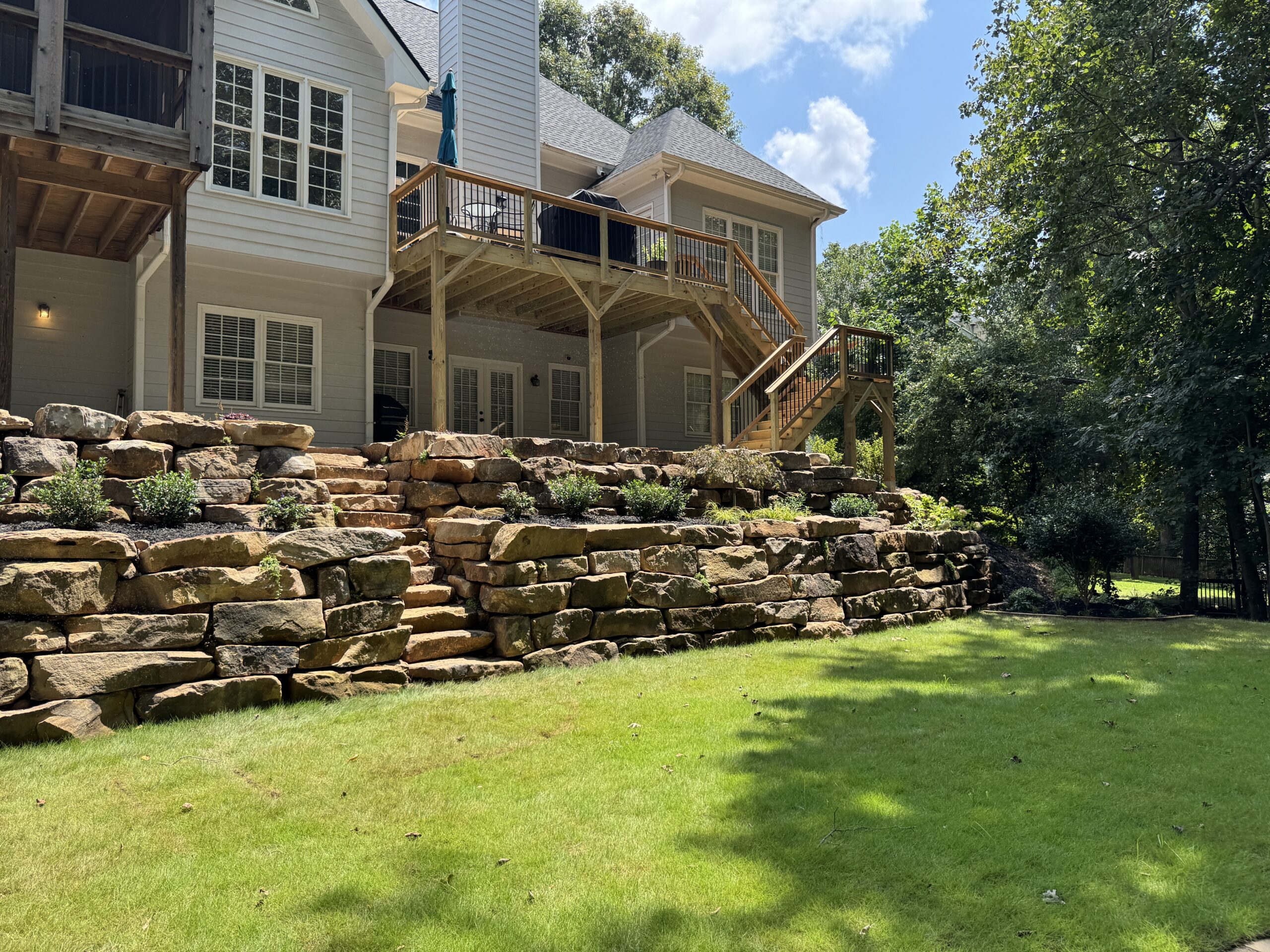 Backyard landscape with custom stone retaining wall.